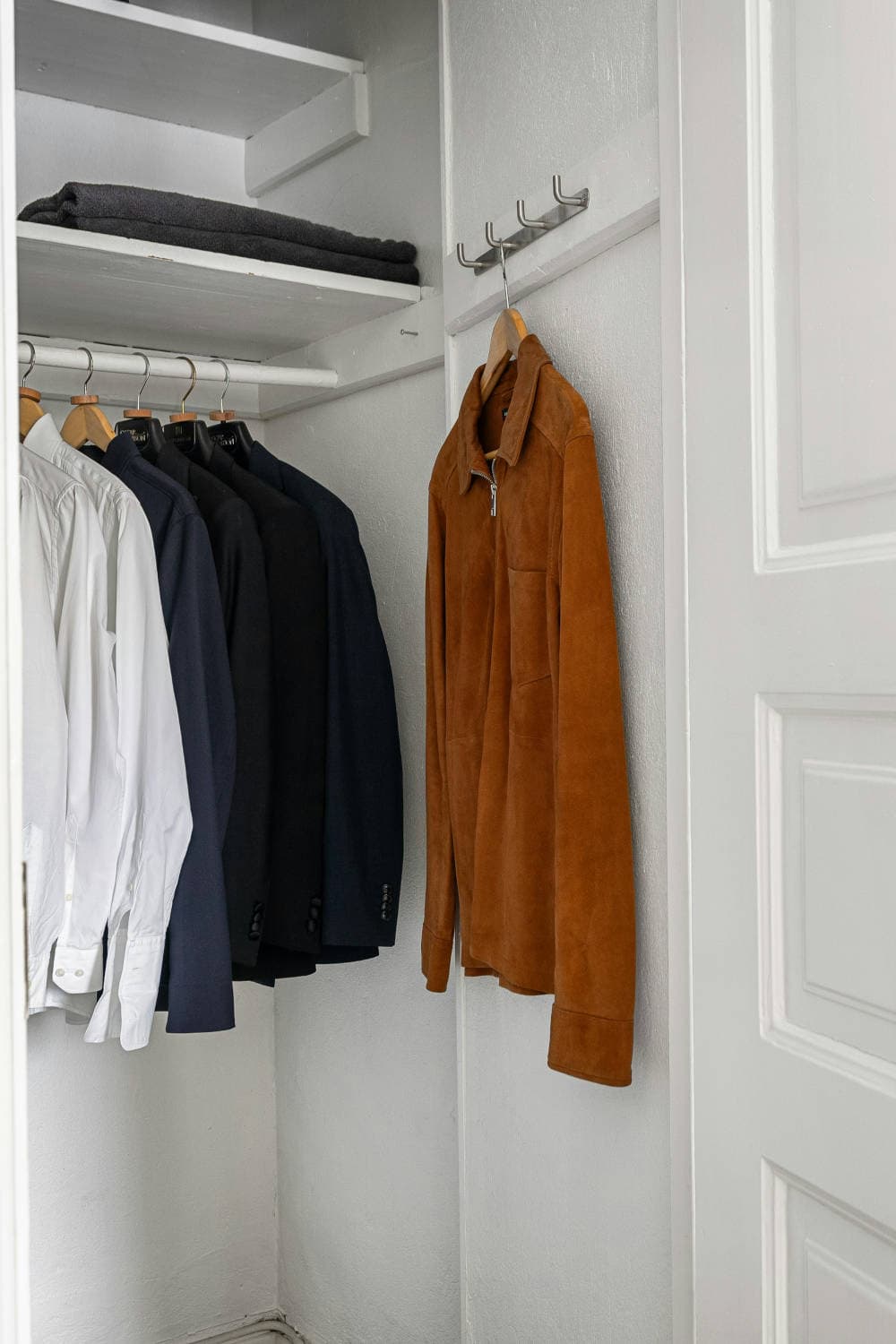 Minimal, coordinated men's wardrobe pieces on hangers